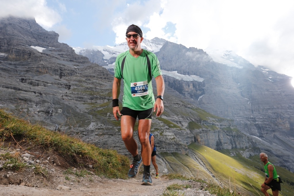laeufer_2016_17_gross Läufer des TV Wolfenweiler-Schallstadt in grünem Trikot auf einem Bergpfad vor Alpenkulisse
